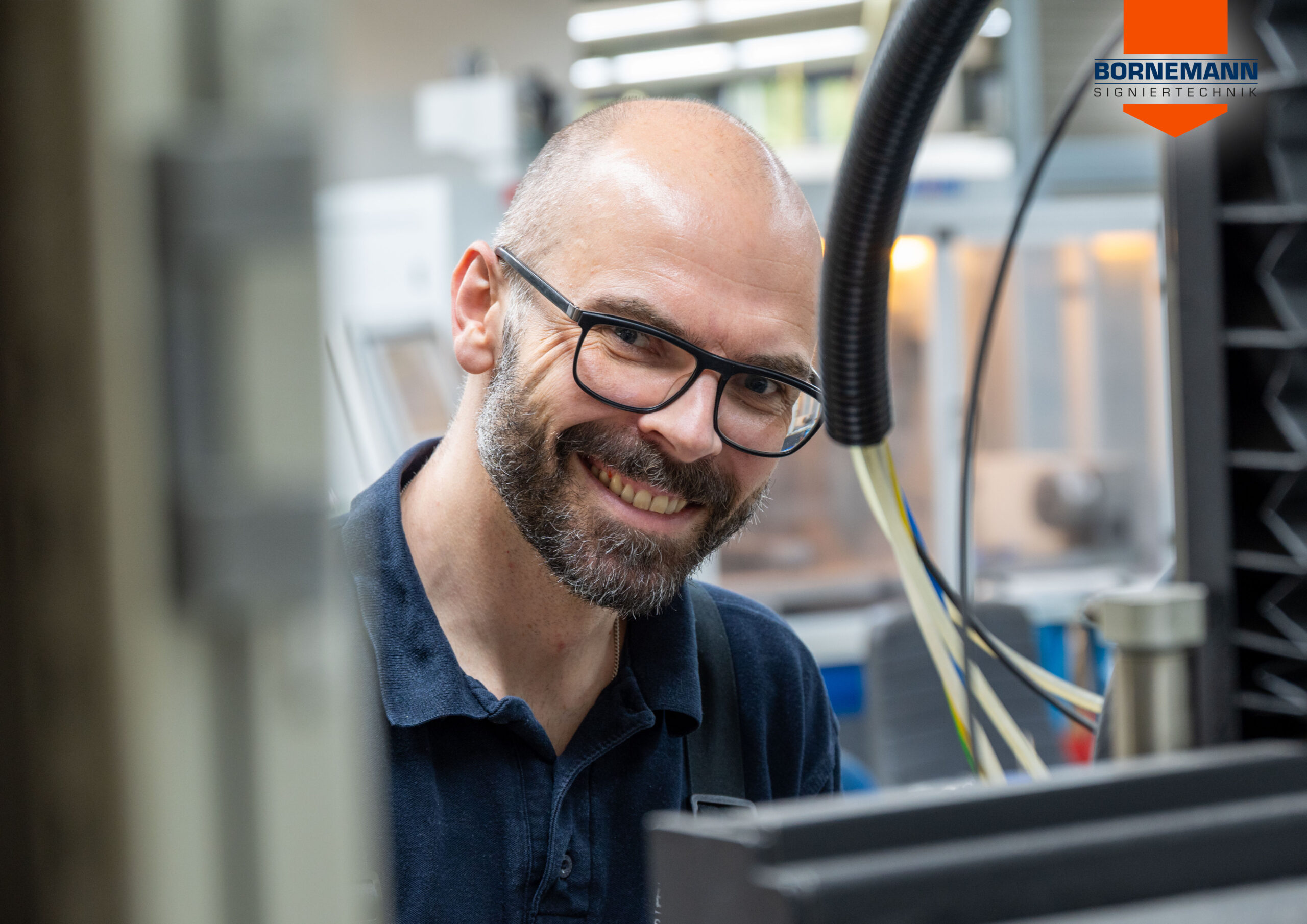 Mitarbeitende in der Bornemann Produktion bei der Bearbeitung eines Prägestempels an einer Maschine.