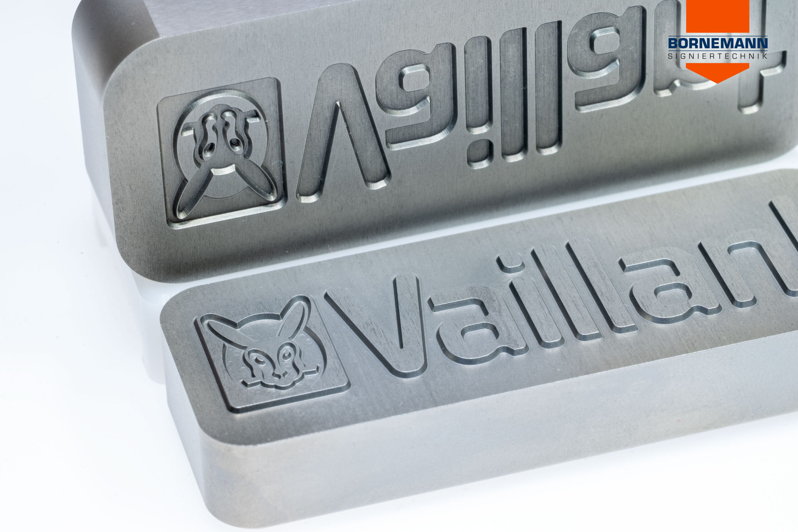 Patrize und Matrize eines Prägestempels im Detail, mit Logo „Vaillant“ als Beispielprägung.